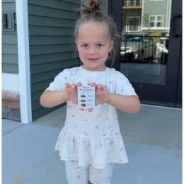 a little girl wearing a gift card