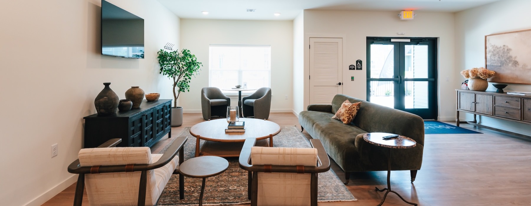 a clubroom with a tv, couch, tables and chairs