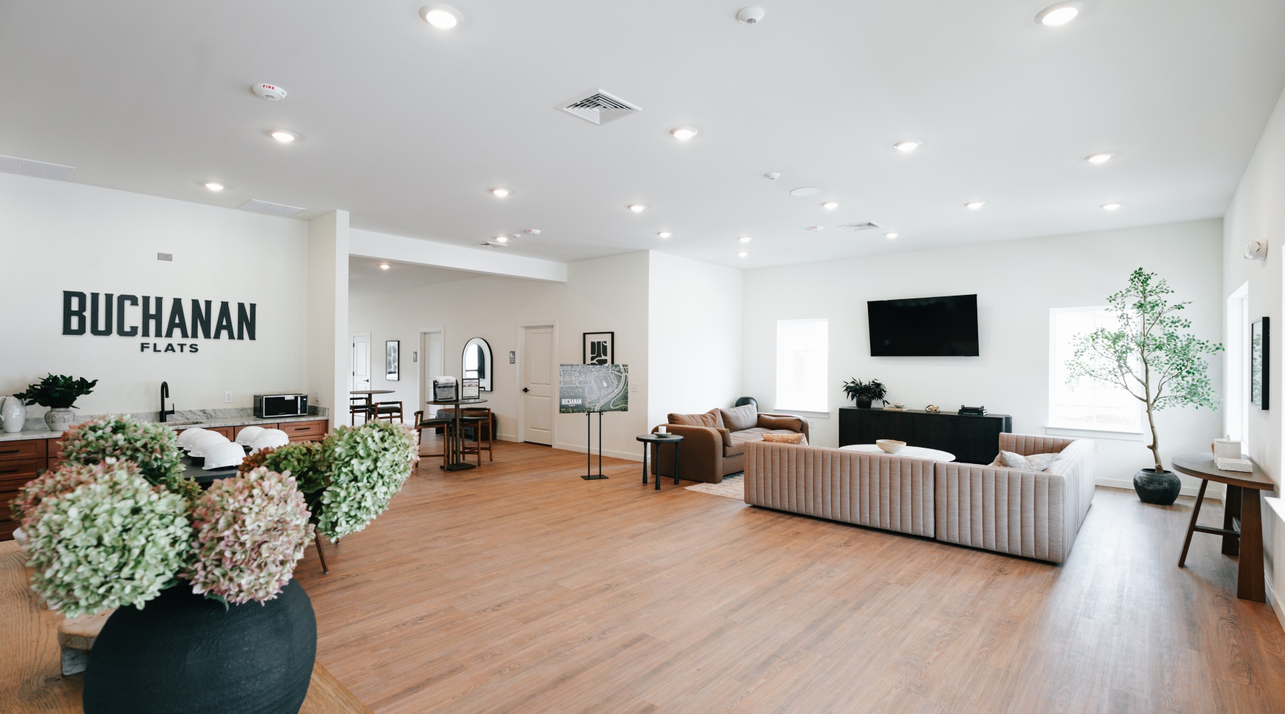 a clubroom with a couch, tables and chairs