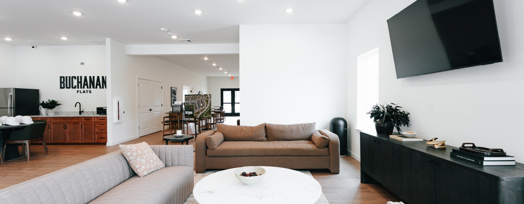 a clubroom with a tv, couch, tables and chairs