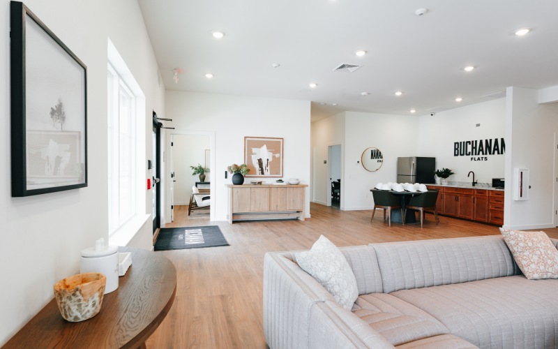 a clubroom with a tv, couch, tables and chairs
