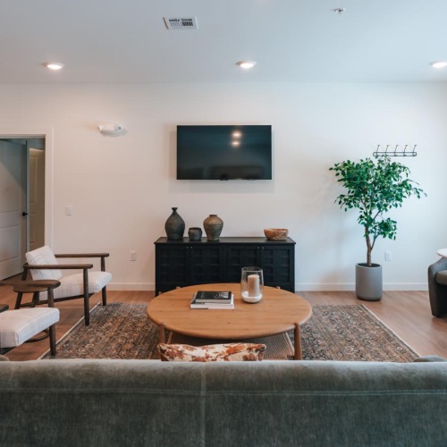 a clubroom with a tv, couch, tables and chairs